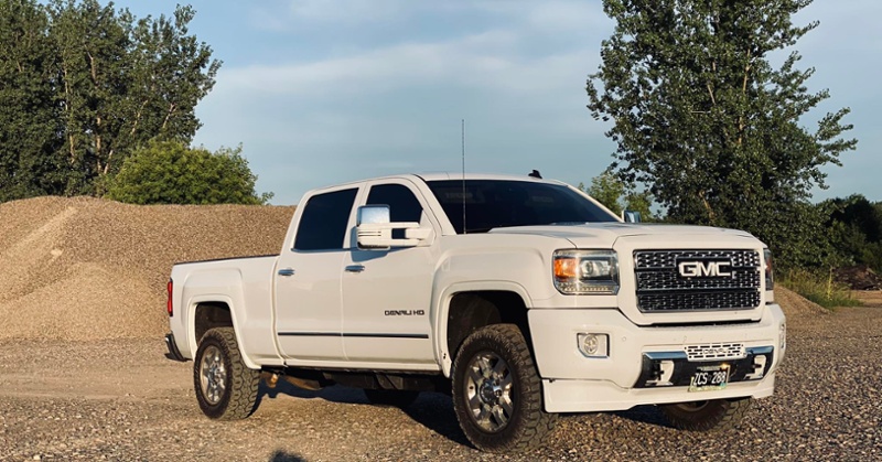 White GMC pickup truck pictured in a dirt lot.