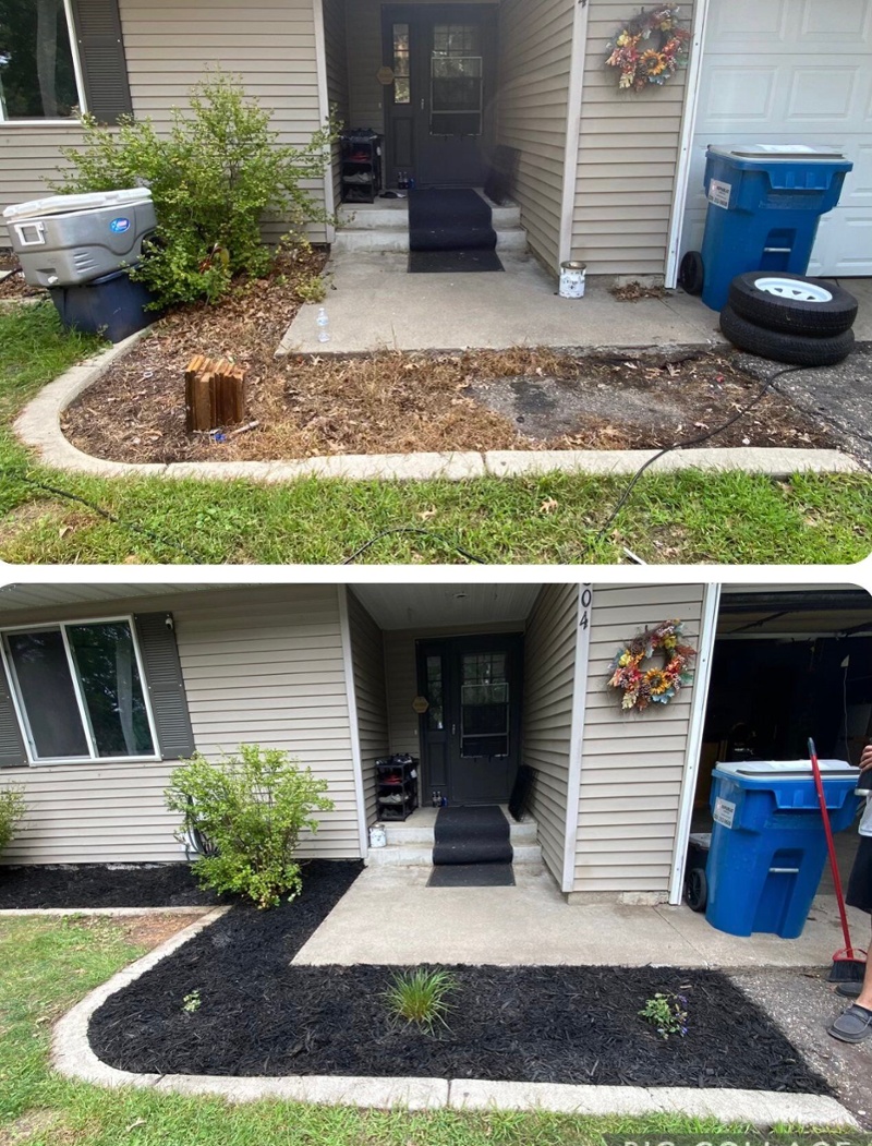 Refreshed entry way to a home with new mulch, plants, and cleaned concrete.